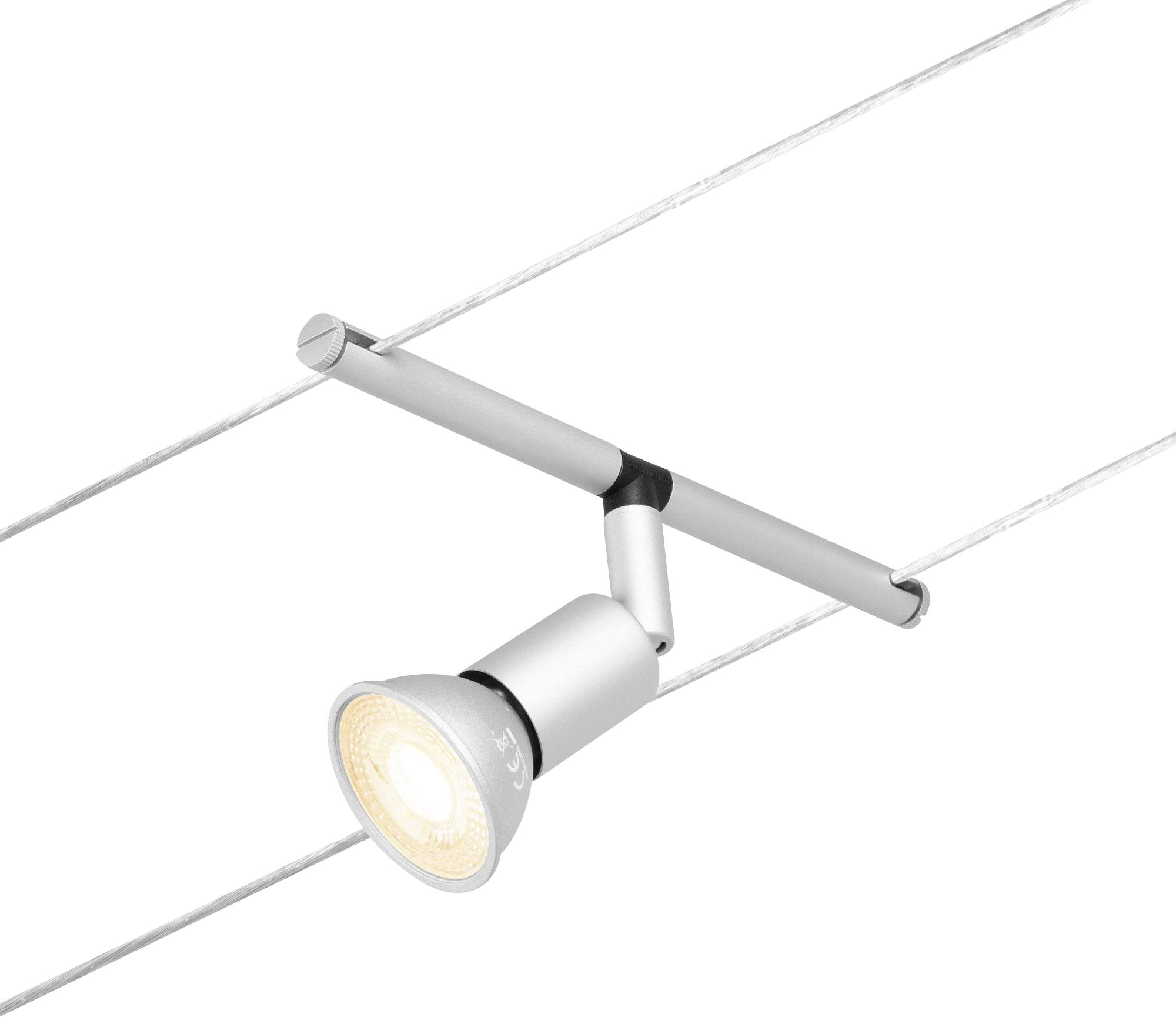 A single silver ceiling spotlight with a swivel arm, mounted on two parallel cables, emits diffused, yellowish light.