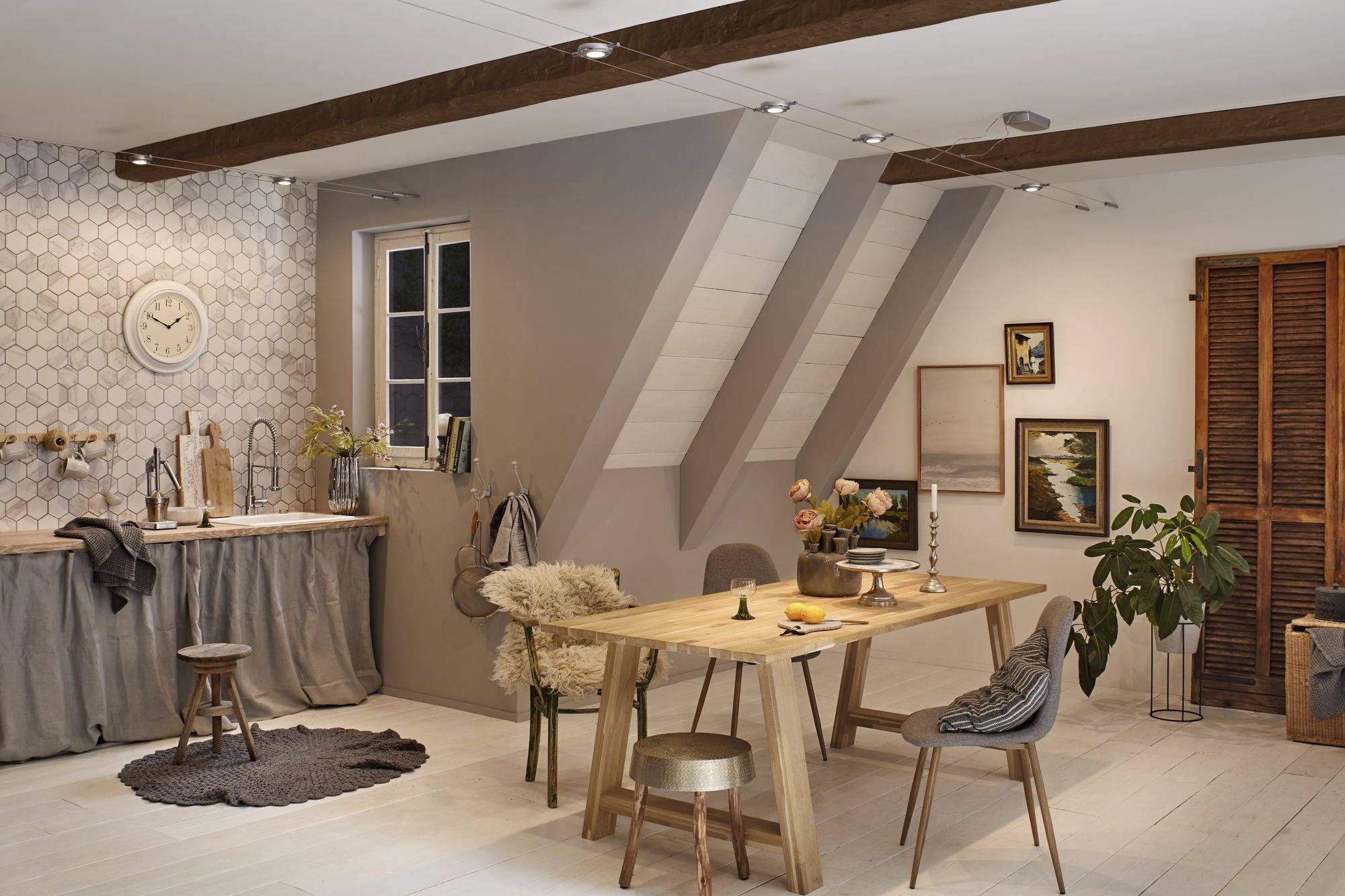 A cosy dining room with a wooden table, chairs and decorations. A clock and a small window are visible on the left wall.
