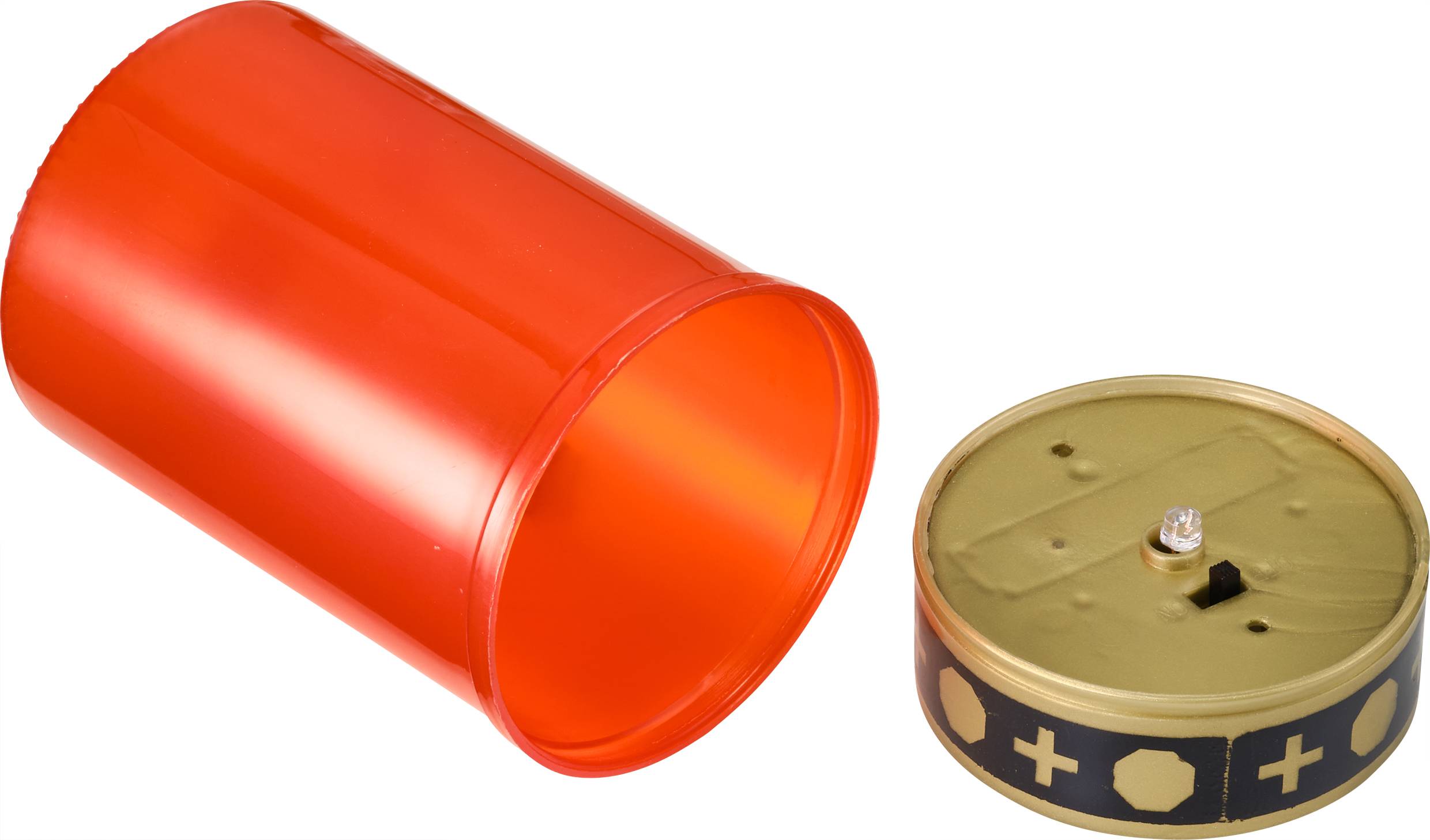 Red grave candle with a removed gold-coloured lid, decorated with black and gold crosses.