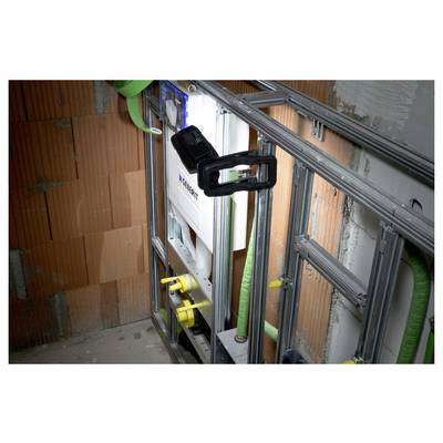 Partially built interior wall framing with metal studs, insulation and green pipes around a recessed mechanical unit with yellow valves.<br>