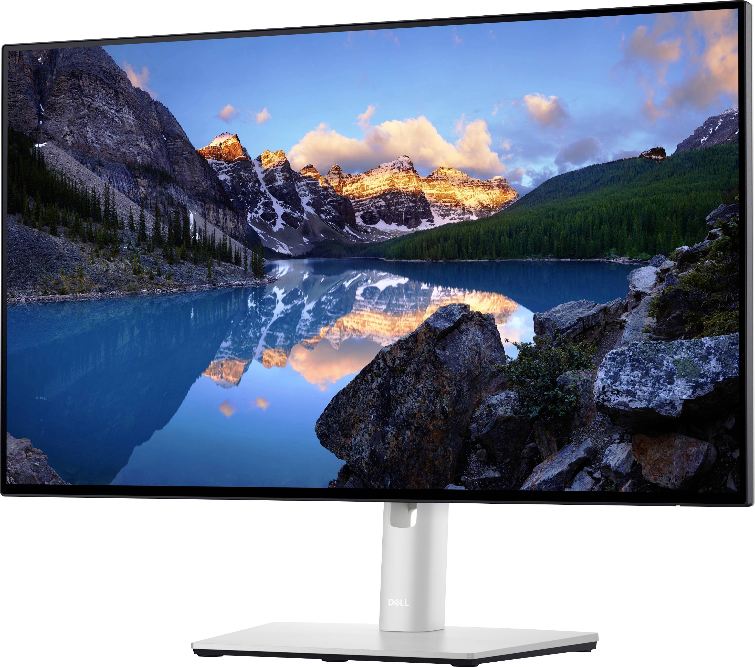 A computer screen displays a landscape with a serene lake, reflecting snow-capped mountains and a clear, blue sky.