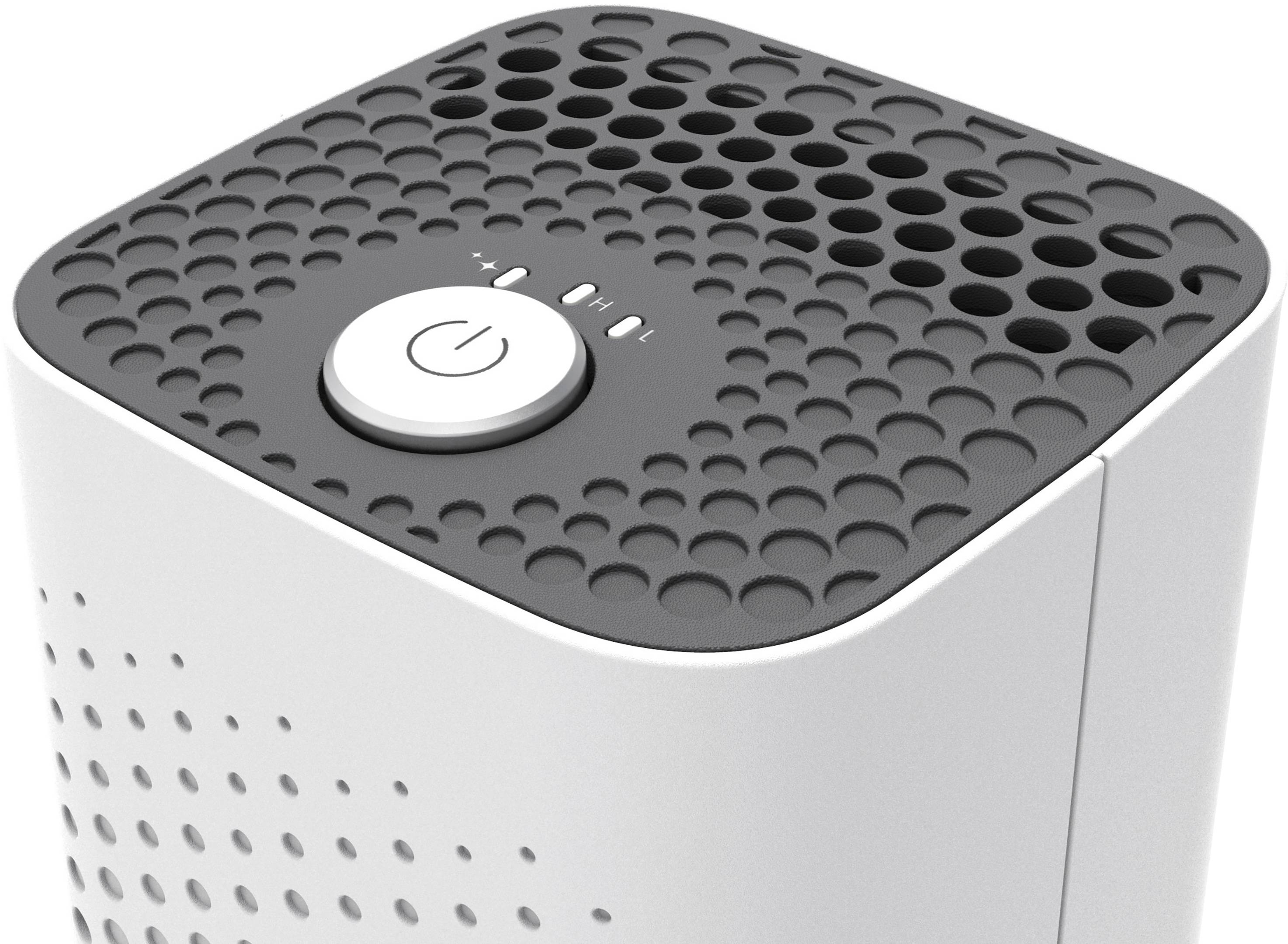 Air purifier with a grey top surface and round ventilation slots. A large power on/off button is located in the centre.