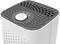 Air purifier with a grey top surface and round ventilation slots. A large power on/off button is located in the centre.