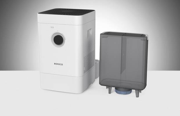 Humidifier with a rectangular design and removable water tank, placed on a grey surface against a grey background.