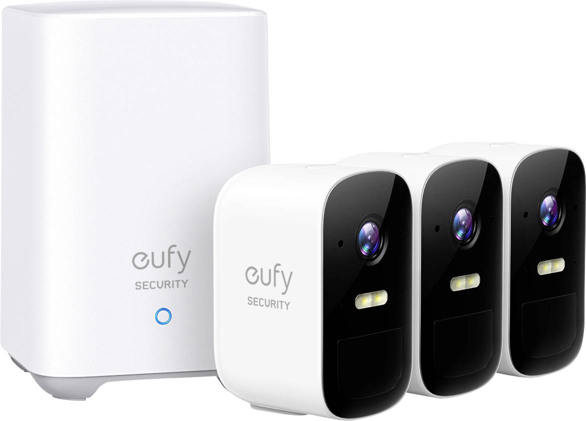 Three white security cameras and a base station from Eufy, lined up in a row. The cameras have a black front area.