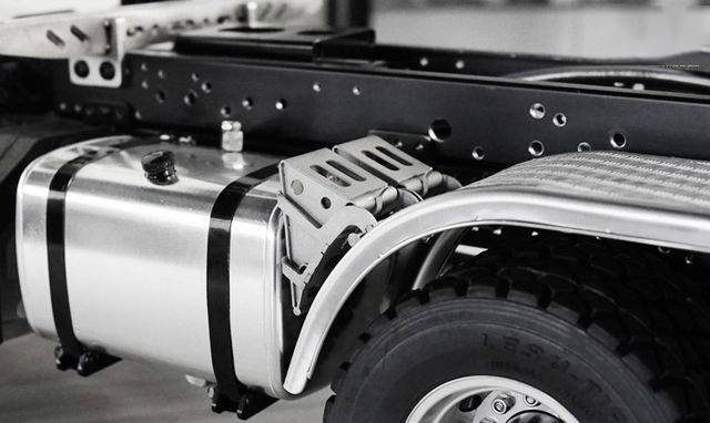 Close-up of a lorry's chassis and fuel tank. The tyres, metal framework, and mounting components are clearly visible.