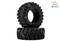 Two large, black off-road tyres. One stands upright, the other lies in front of it. Brand logos in the top right of the image.