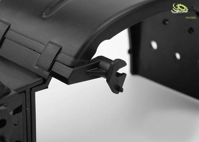 Close-up of a black plastic component with a hook, likely a part of a larger model or device.