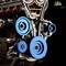 Close-up of a model engine with blue pulleys and visible gears.