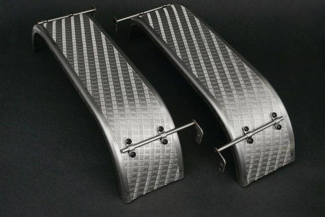 Two curved metal structures with an embossed pattern and screws on a black background.