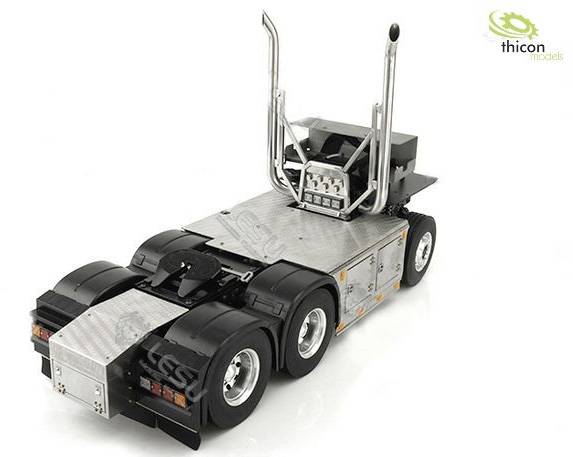 Model of a black and silver articulated lorry on a white background. The vehicle has two rear axles.