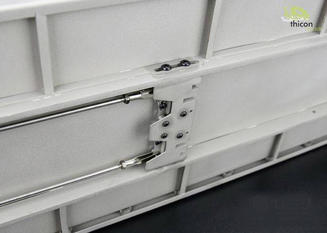 Close-up of a hinge on a white metal casing with multiple screws and metal rods reinforcing the structure.