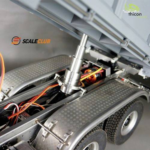 Close-up of a model lorry trailer with raised tipping mechanism, with hydraulic cylinders and cables visible.