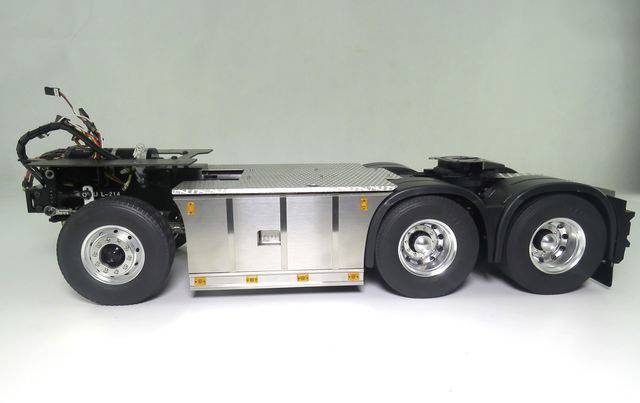 A model lorry chassis with six wheels. It shows the arrangement of the wheels, axles, and an empty load bed.