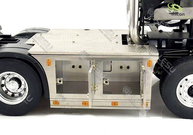 A lorry chassis with metal plate covering and open storage compartments mounted on the vehicle's side.