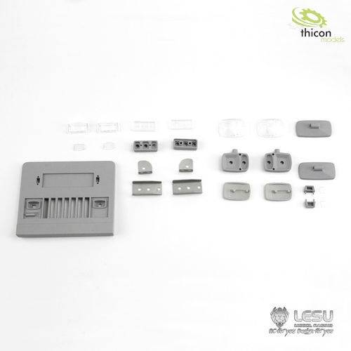 'Several small grey and transparent model components, including rectangular and round shapes, are arranged on a white background.'
