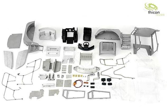 Various metallic and plastic model components are laid out on a surface, suitable for model building or repairs.