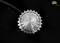A metallic gear wheel against a black background, detailed view. The precisely machined surface reveals multiple small perforations.