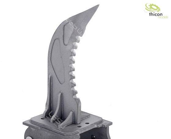 Metal component with serrated edge and pointed tip, mounted on a base. A company logo is visible in the top right corner.