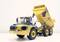 Large, yellow construction vehicle with a tilted cargo area on a white background. Robust, suitable for heavy loads.