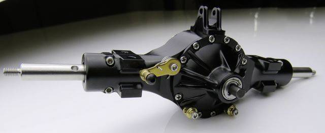 A black differential of a vehicle axle, lying on a white background. It shows screws, bolts, and moving parts.