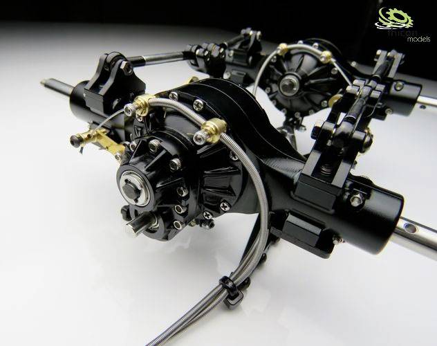 Close-up of model car axles and transmission components on a white background, with detailed metallic structures visible.