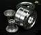 Silver metallic model-building parts, including a large wheel hub adapter and other components, on a black background.