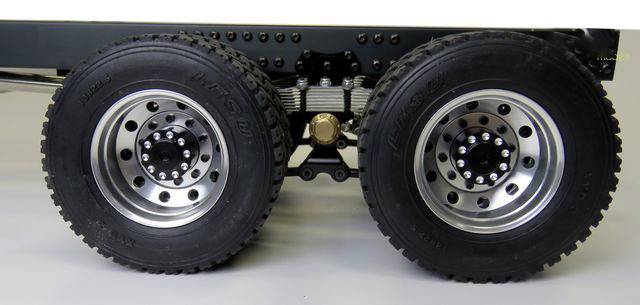 Close-up of two robust lorry wheels on an axle, suitable for off-road use. The tyres have a coarse tread pattern.