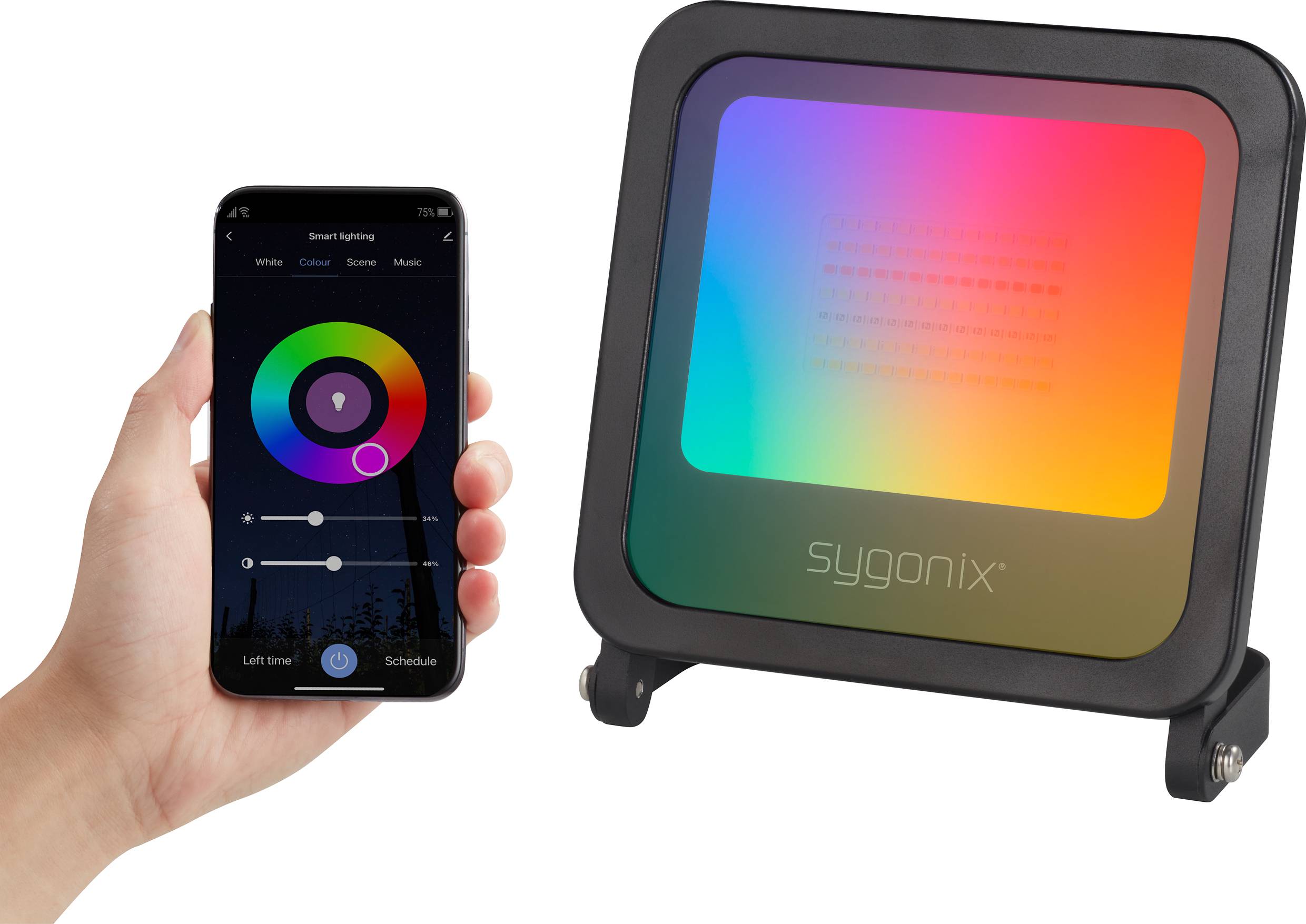 A hand is holding a smartphone with an app used to control a colour-changing LED lamp, which is situated beside it. The lamp is illuminating in rainbow colours.