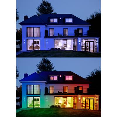 Two-storey house at dusk, illuminated with blue light on the upper floor, and multi-coloured lighting on the lower floor. Modern design with expansive windows.