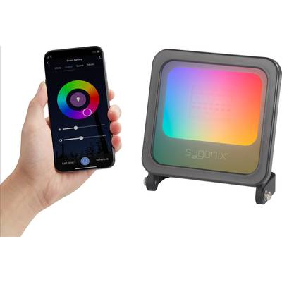 A smartphone controls a colourful LED projector. The app displays a colour ring for light control. The projector illuminates in rainbow colours.