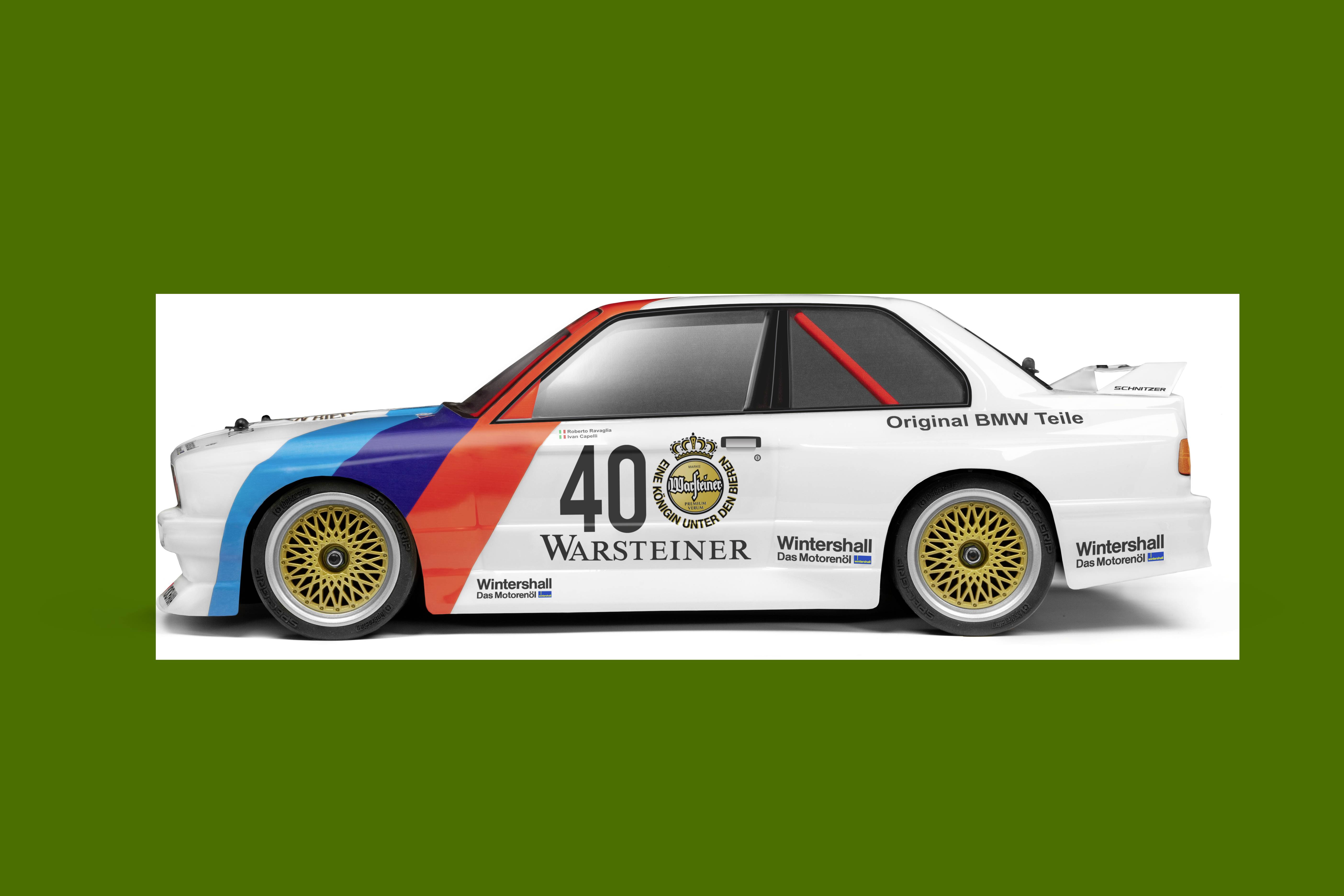 A white racing vehicle, adorned with blue and red stripes, bears the number '40' and the Warsteiner logo on its side.