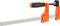 An orange G-clamp with a black, ergonomic handle is gripping a piece of metal.