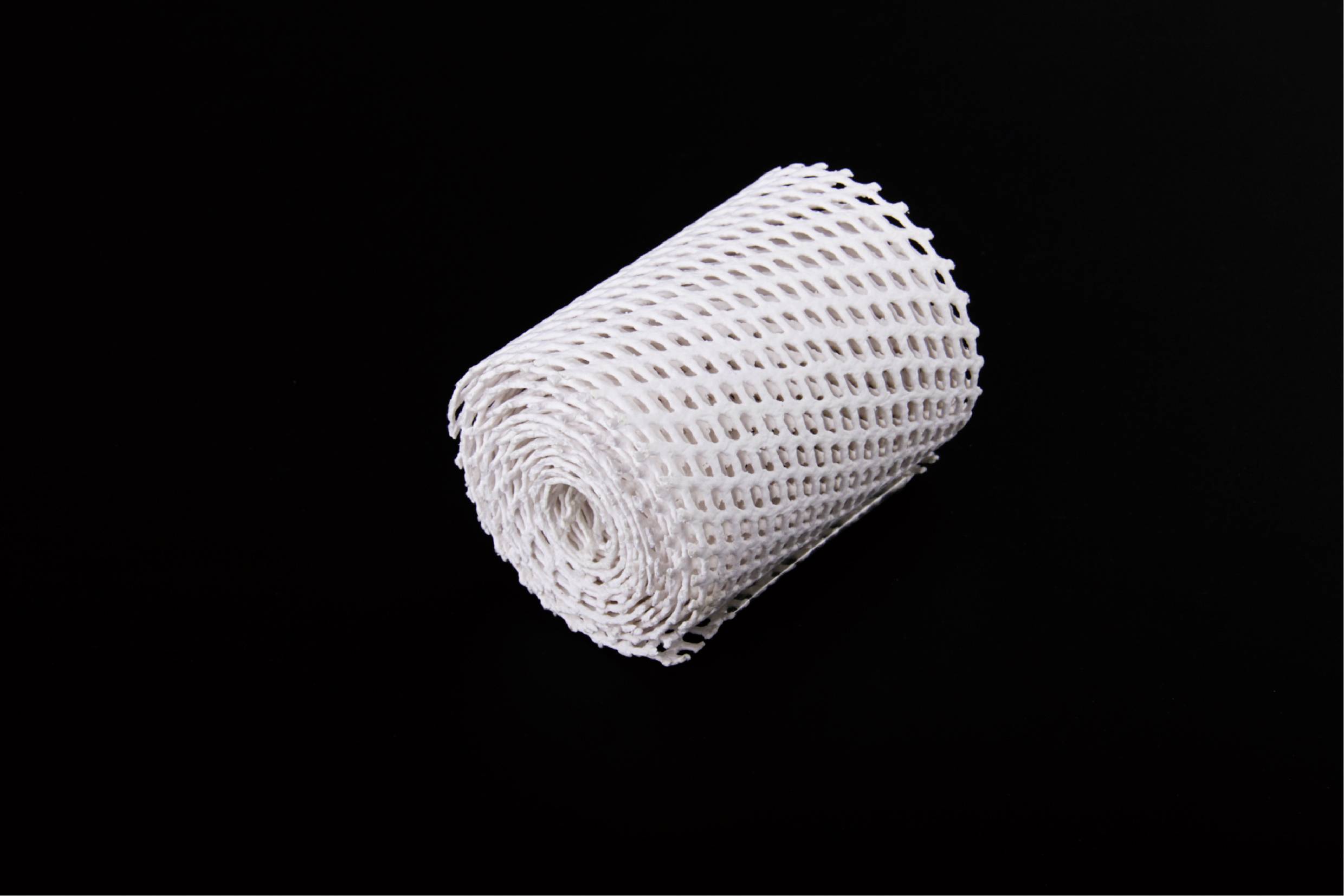 A white, rolled elastic bandage on a black background.