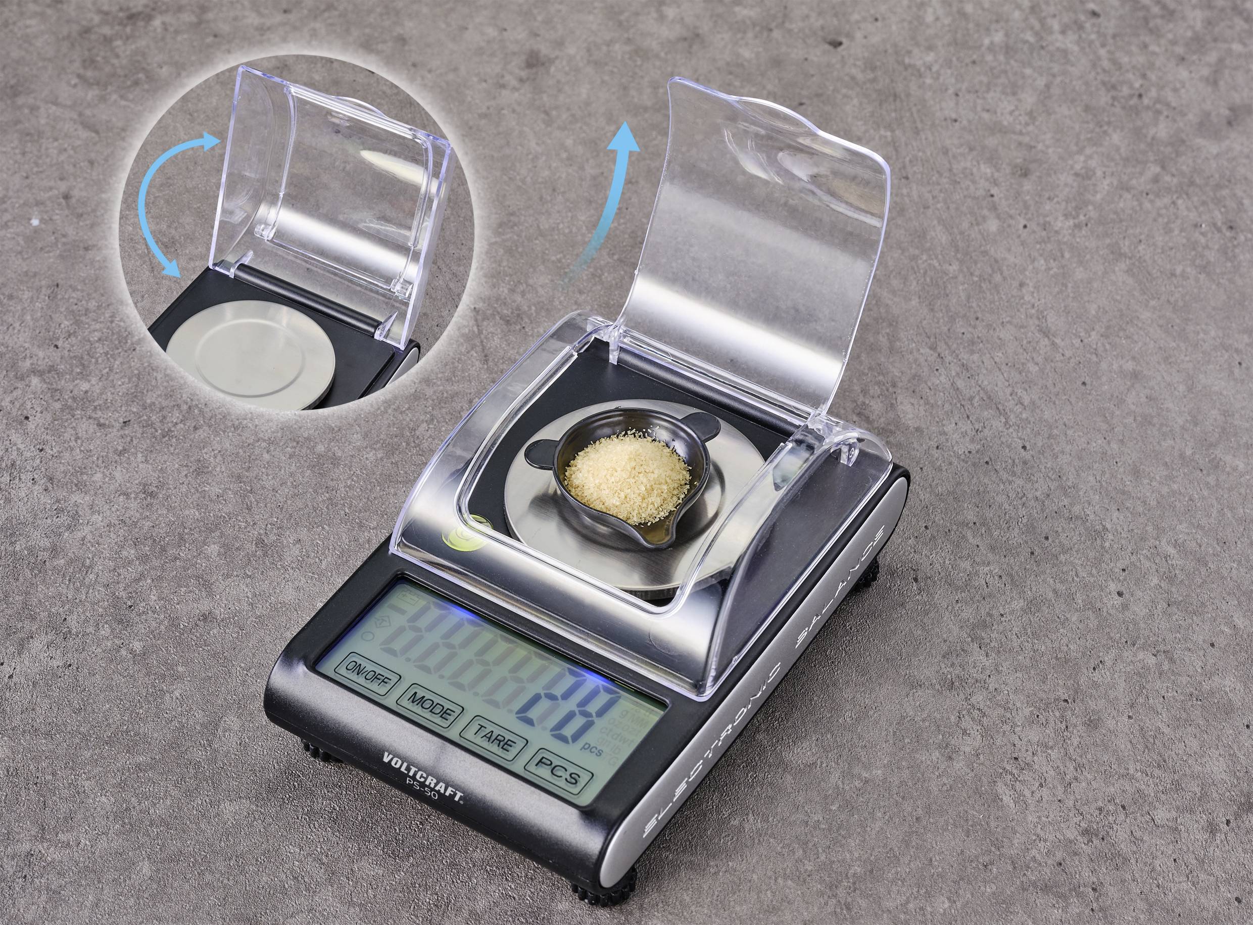 Digital scales with a transparent lid, showing 70 grams of sugar. Inset image demonstrates how the lid opens.