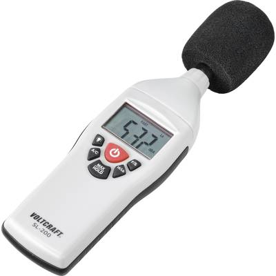 A white sound level meter displays a reading of 57.7 dB. It has a display and several buttons on the front.