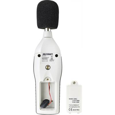A white sound level meter with a black microphone attachment, with the battery compartment open and an empty housing part beside it.