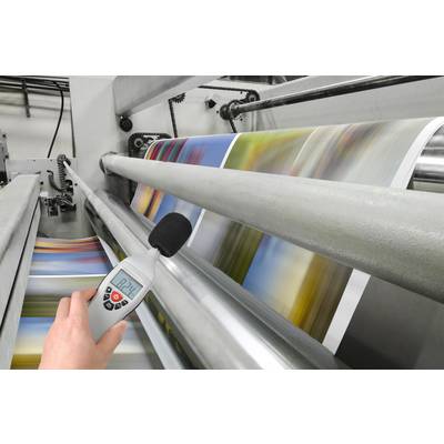 Colour printing press. A decibel meter measures the noise level at 82.1 dB near the machine.