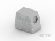 A silver, rectangular housing component with a side opening and two lower connections, potentially for technical applications.