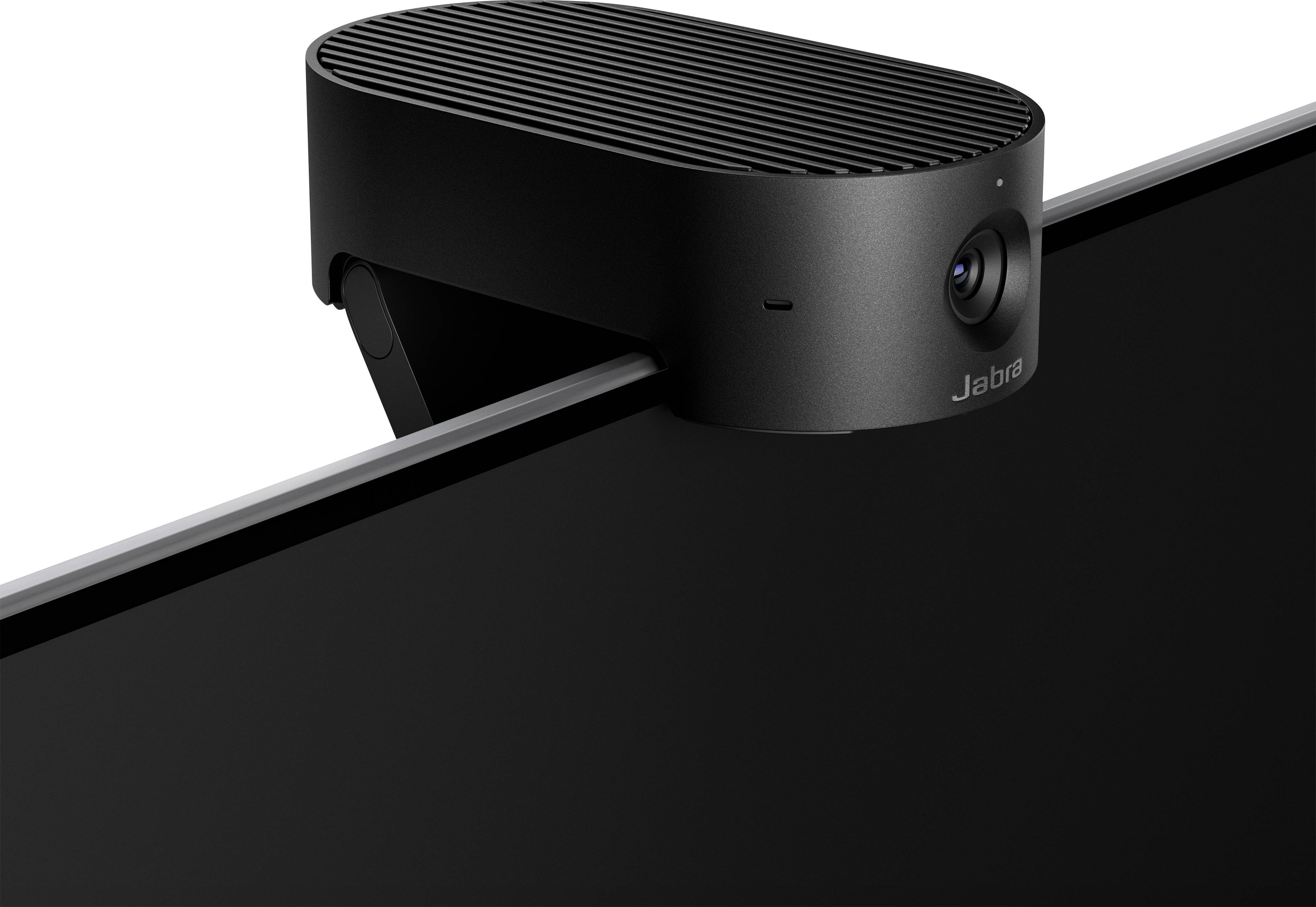 A black conference camera sits atop a monitor, with a sleek, oval design and a small lens on the front.