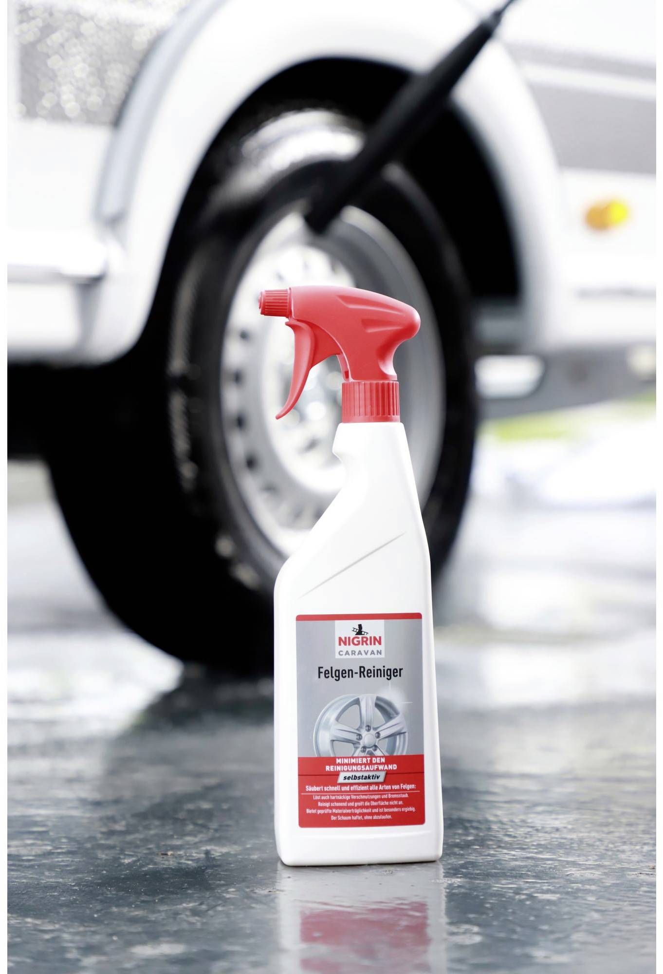 'Spray bottle with wheel cleaner in front of a car tyre'