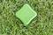A green electronic device for animal deterrence lies on grass-covered ground.