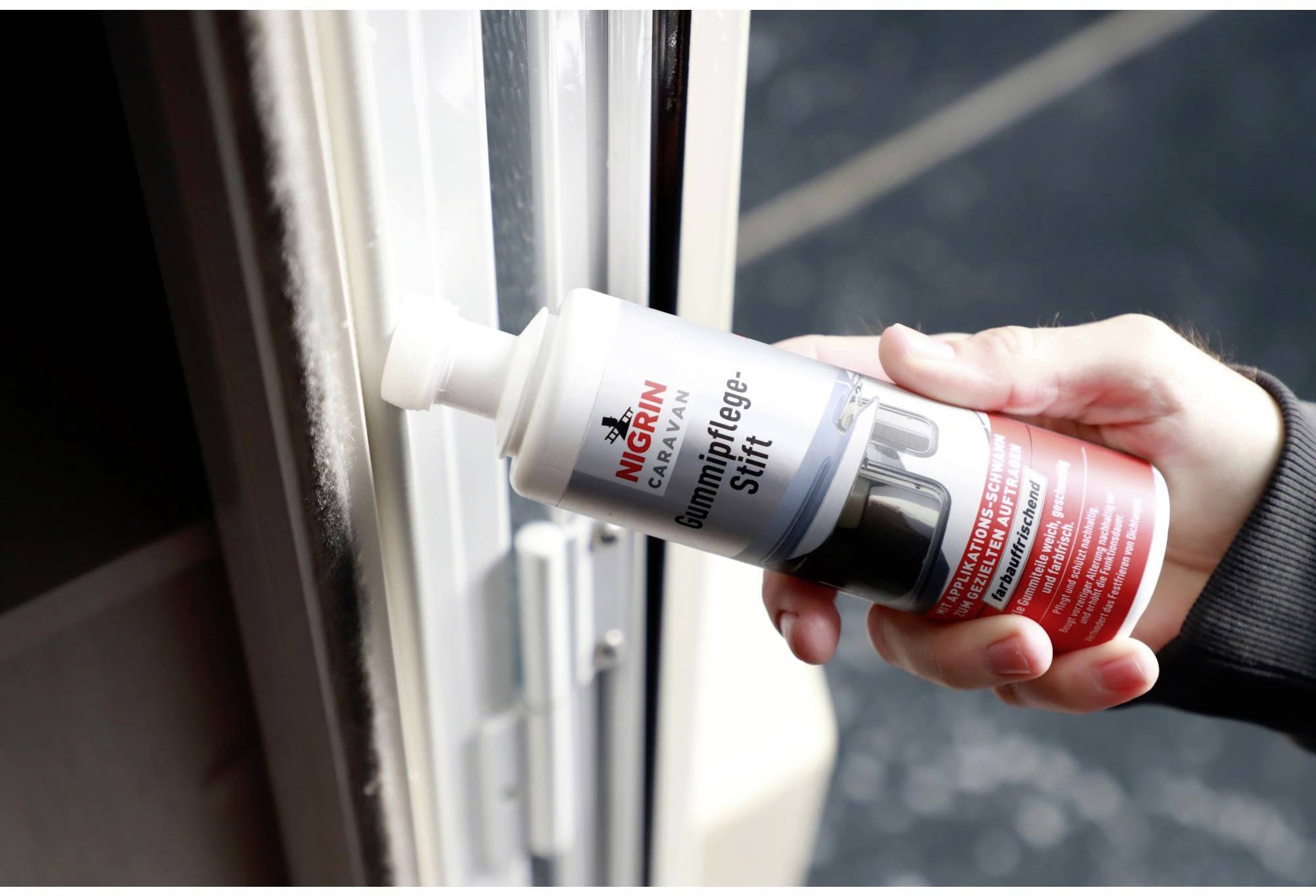 A hand holds a rubber care stick and applies the product to the rubber of a door seal. The stick prevents the rubber from drying out.