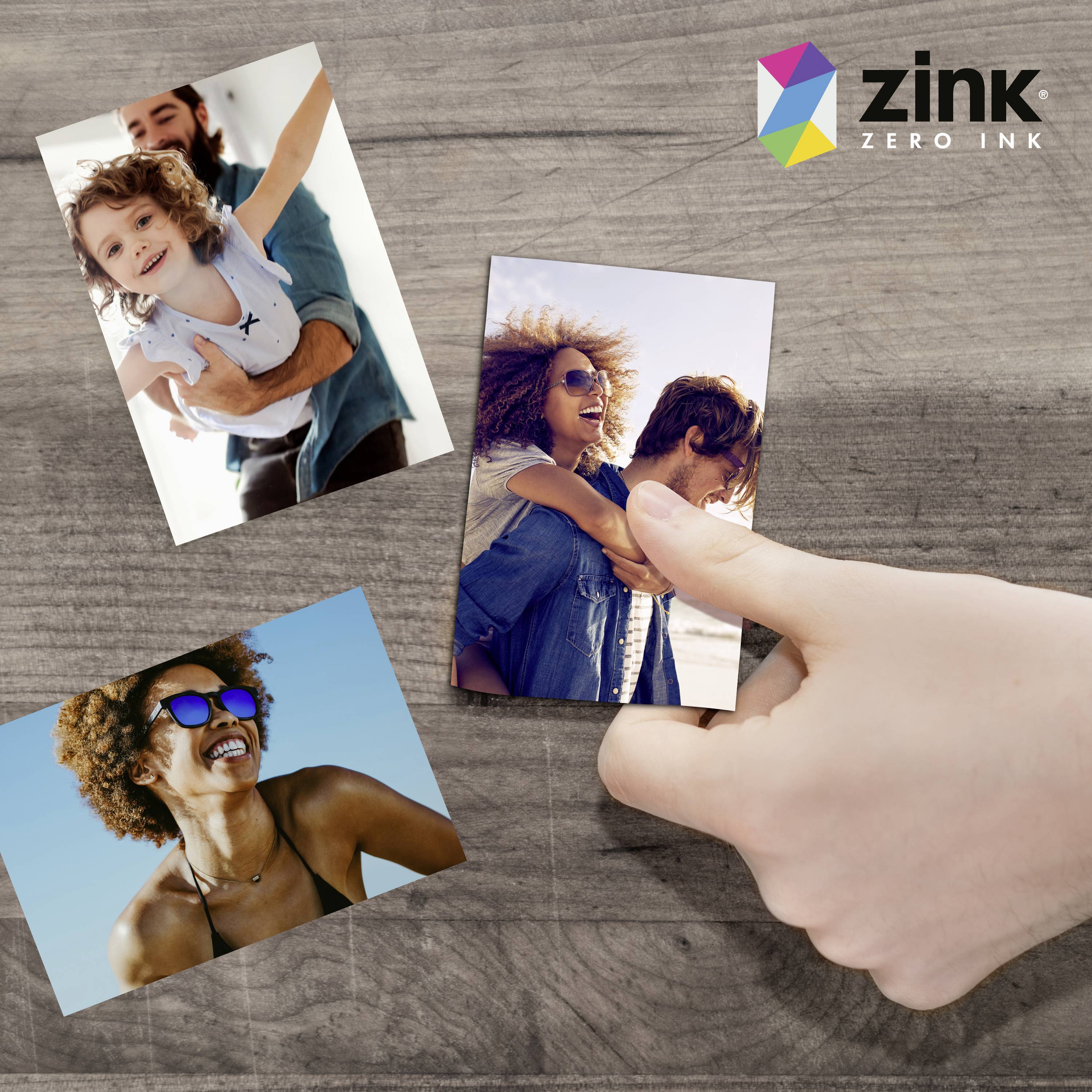 Three photographic prints on wood, held by a hand. Top left: Adult and child smiling happily. Top right: Women embracing. Bottom left: Woman on the beach. ZINK logo in top right corner.