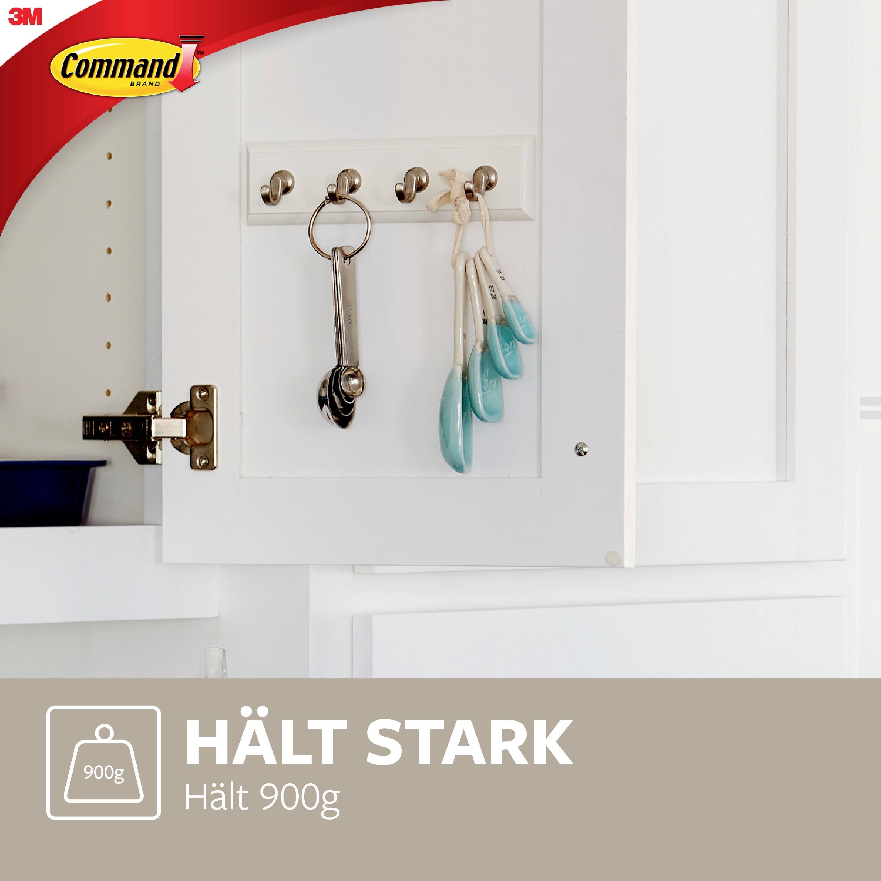 Hook on a kitchen cabinet door holds keys and ladles. Text: 'Holds strong, holds 900g'. 3M Command logo in top left corner.