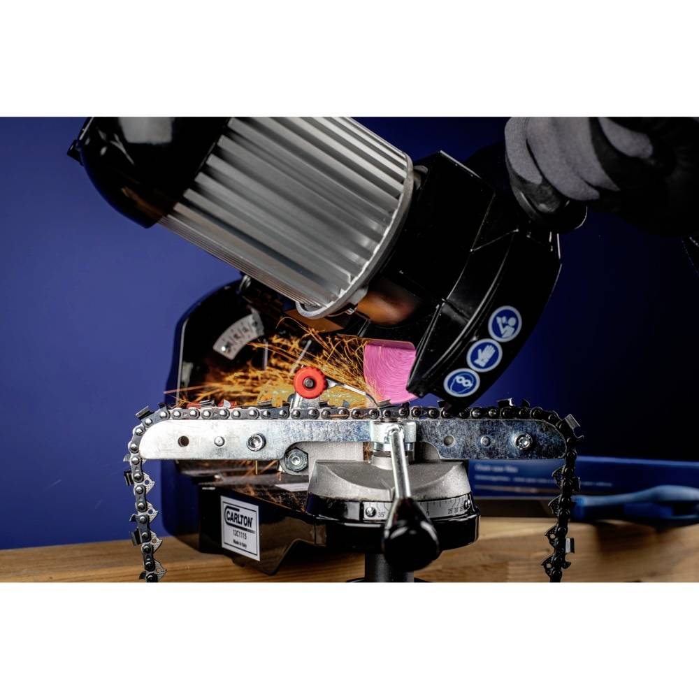 A person is sharpening a chainsaw chain with a grinding machine, sparks flying. Close-up shot, blue wall in the background.