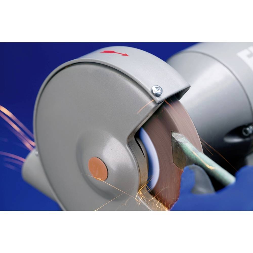 A grinding machine is machining a metal piece, sparks flying.