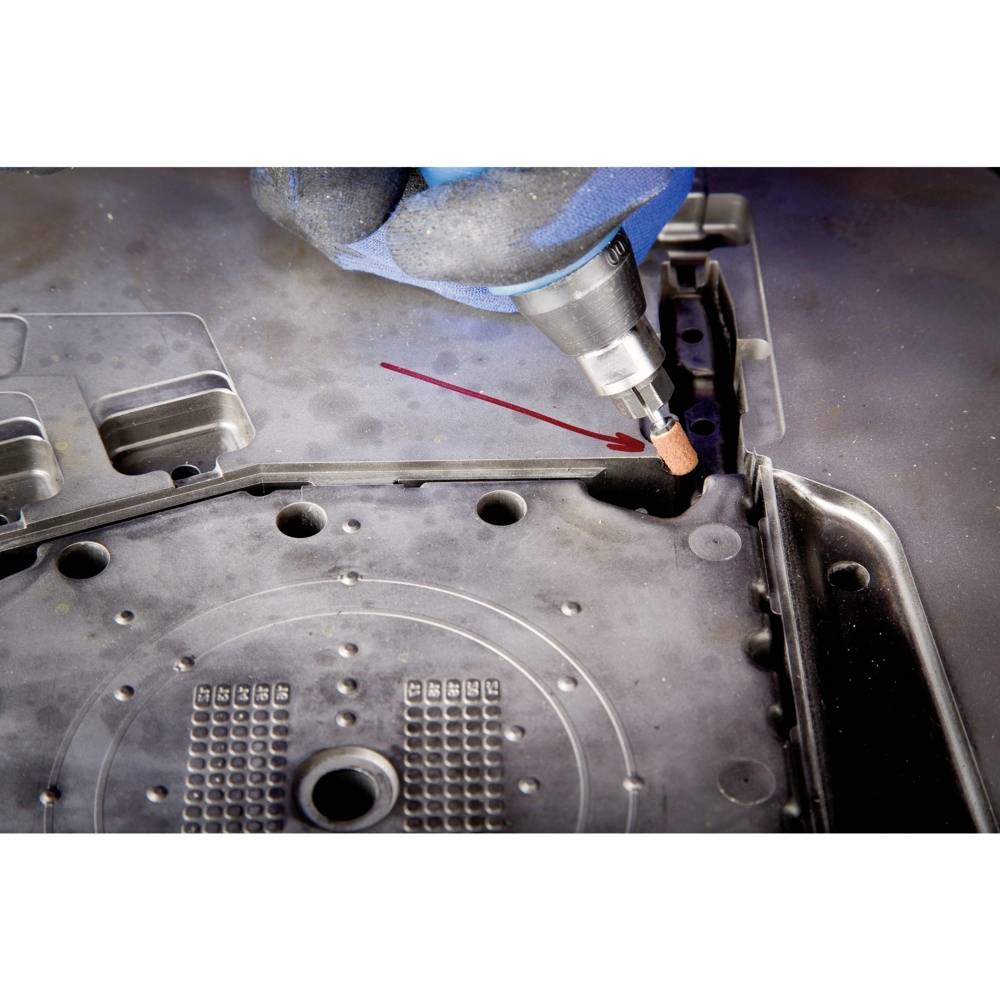 Close-up of a grinding tool working on the edges of a metal casing. The red marked line indicates the grinding direction.