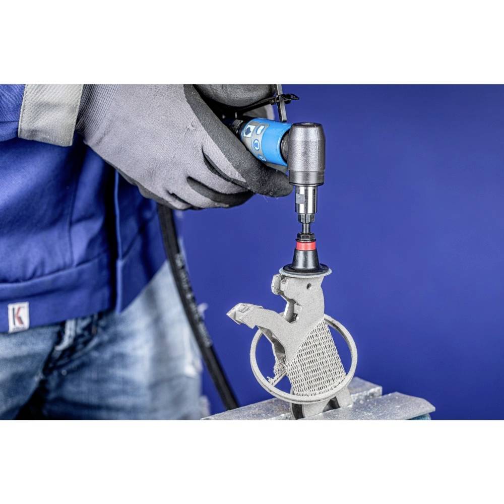 A person is working on a grey metal part clamped in a vice using an electric power tool, against a blue background.