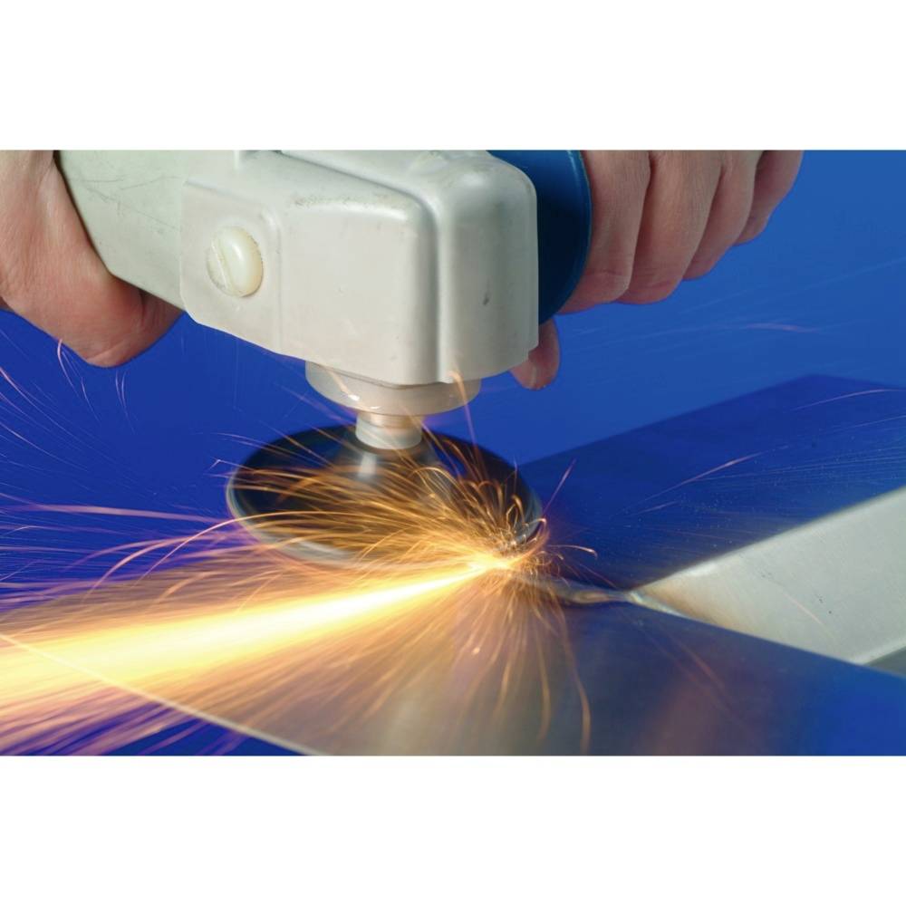 Close-up of a person working with an angle grinder on metal, sparks flying.